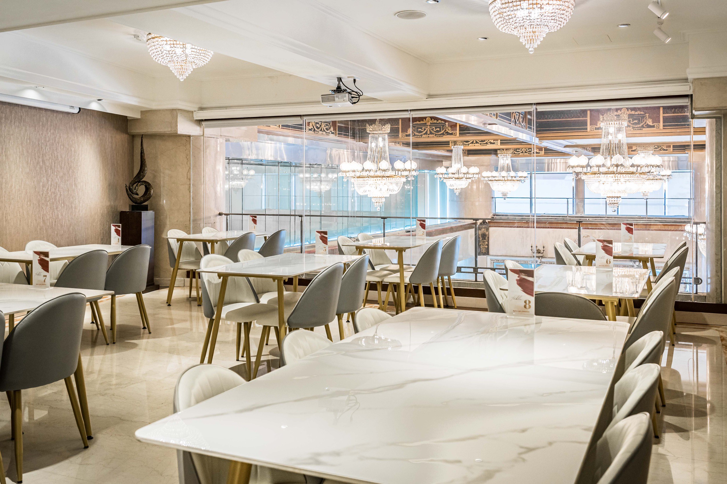 舞齡餐廳入口藝術牆，Ageless Café & Restaurant 標牌、金屬花卉壁飾與圓桌座位